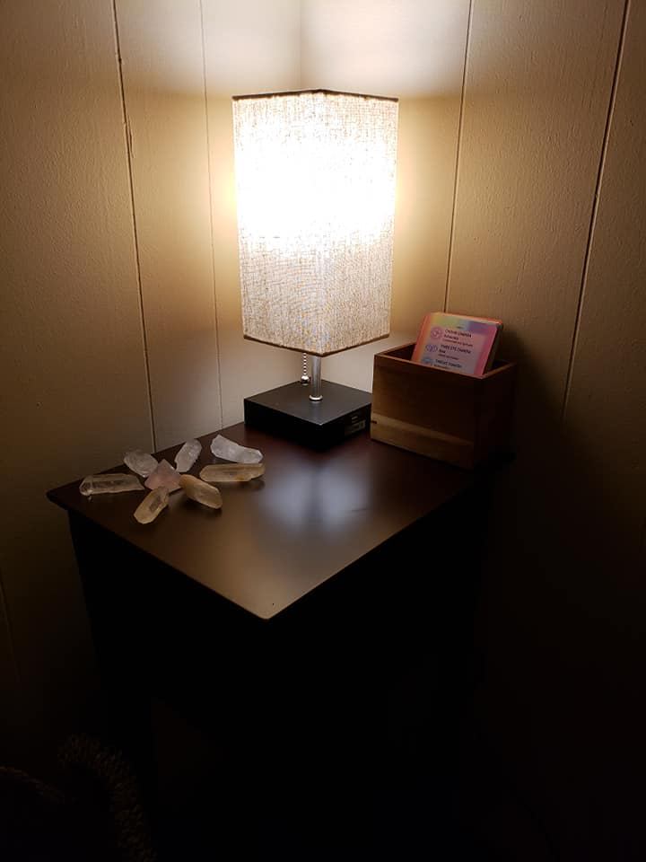 Lamp, crystals and chakra cards on a bedside table